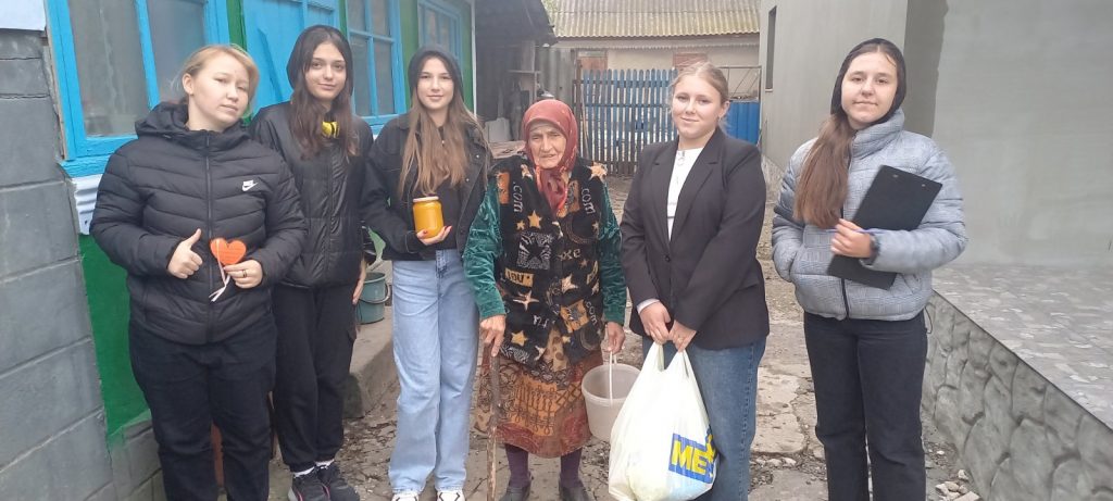 Volunteers with a beneficiary of the food package.