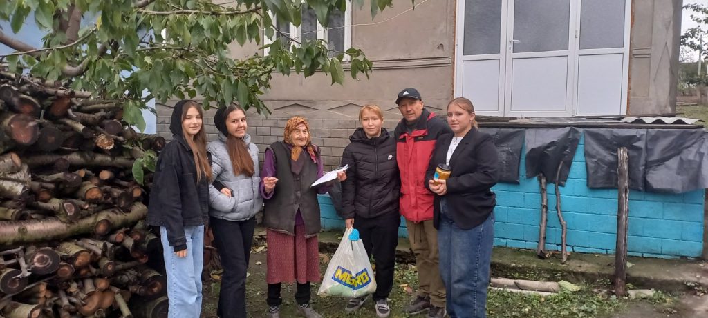 Victor, volunteers, and a beneficiary of the food package.