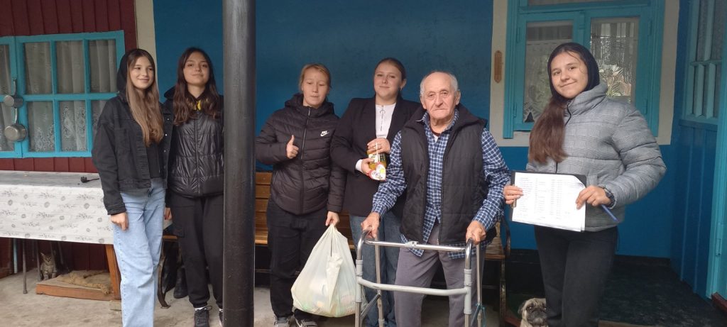 Five volunteers with a beneficiary of the food package.