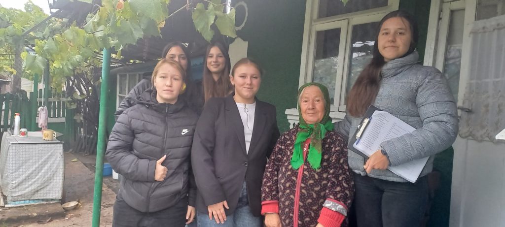 Five volunteers with a beneficiary of the food package.