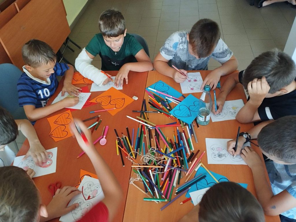 Childreen create greeting cards for the beneficiaries of the food package program.