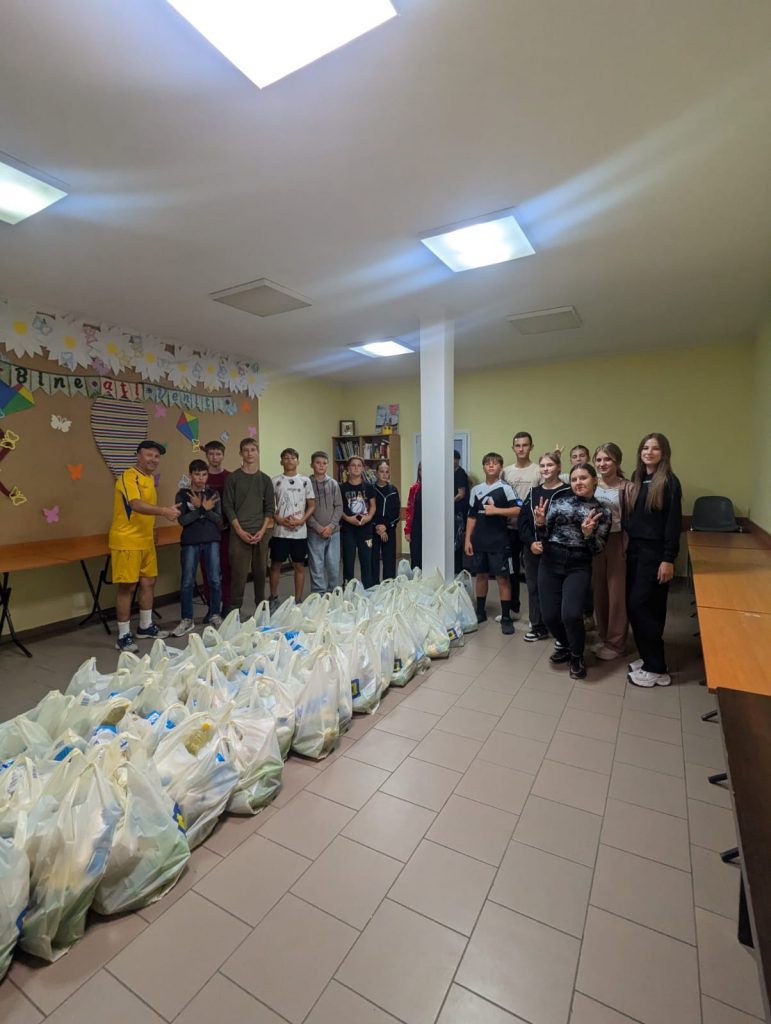 Volunteers posing with 60 completed packages of food for the elderly.