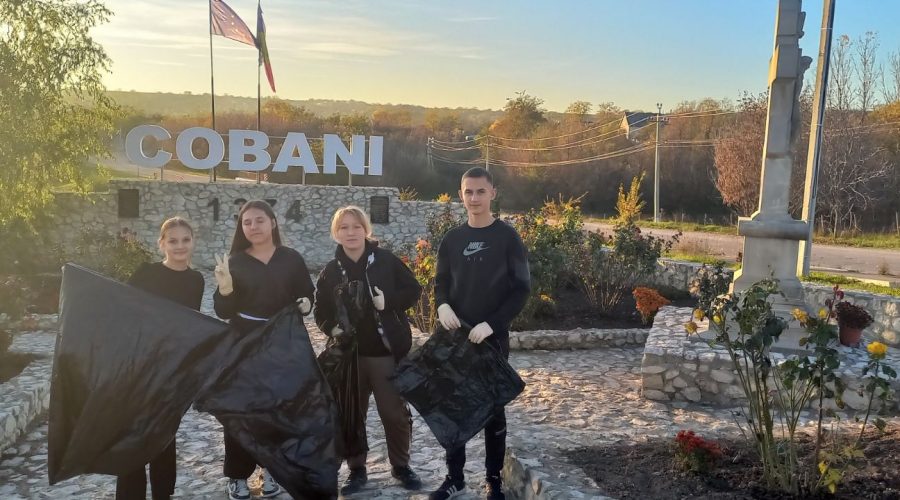 Volunteers posing with trash bags in front of the Cobani sign