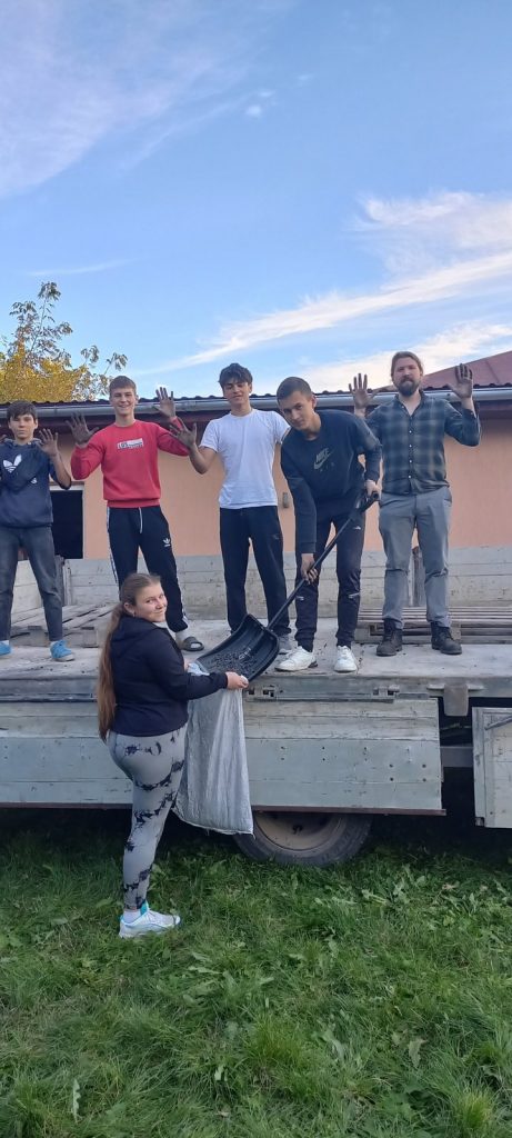 Volunteers cleaning the delivery truckbed after unloading the coal