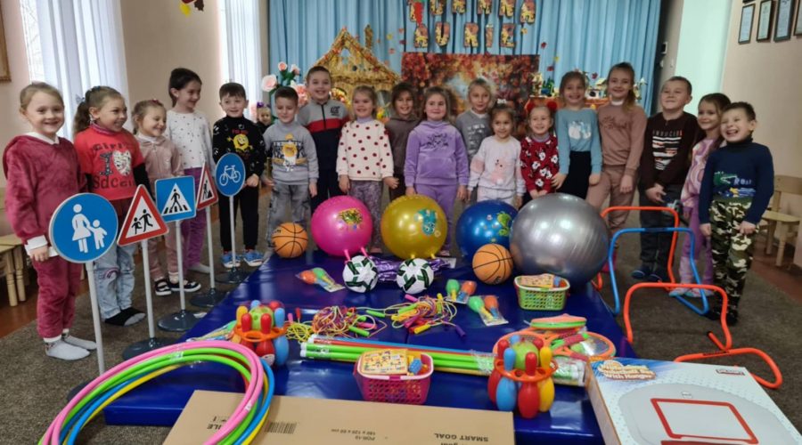 Kindergarten children posing with their new toys.