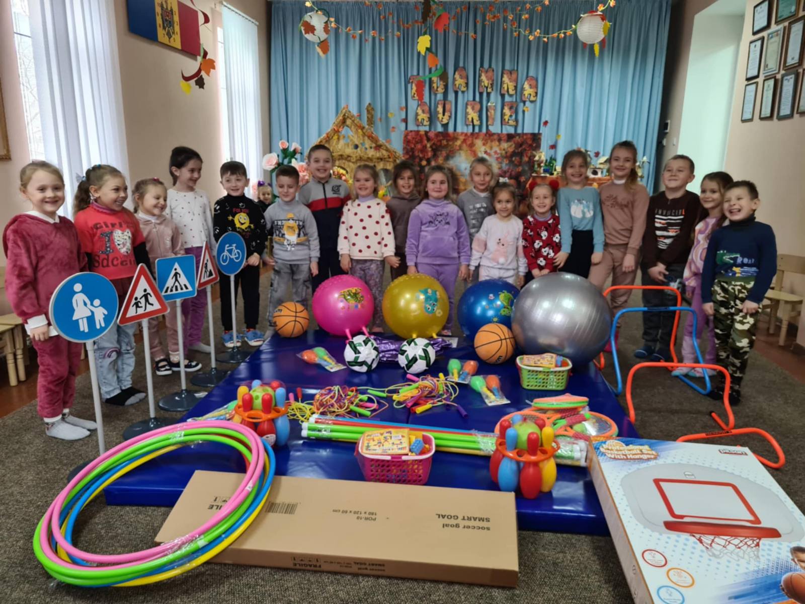 Kindergarten children posing with their new toys.