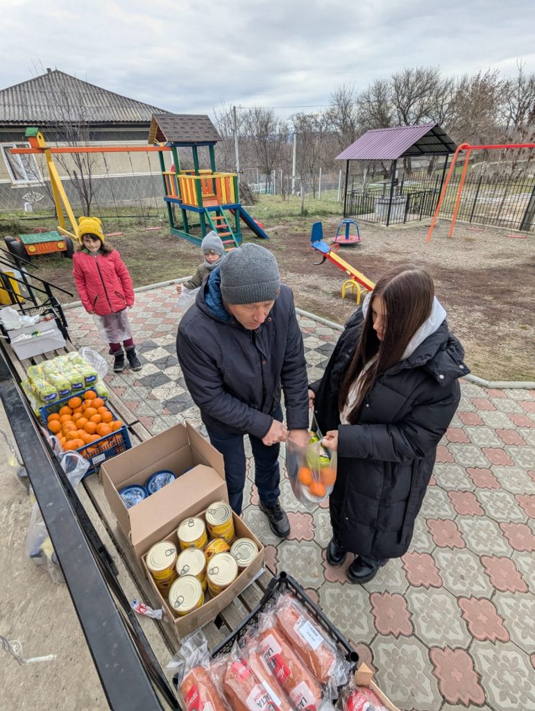 Victor and a volunteer preparing packages of food for the elderly