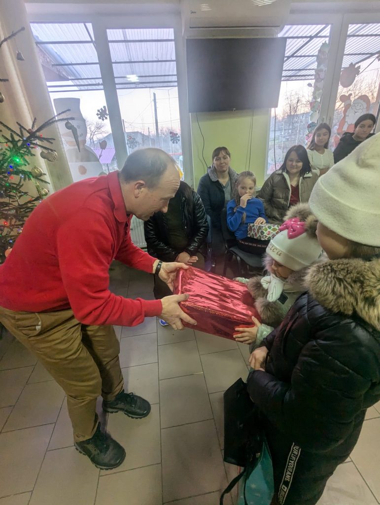 Victor Zama giving a Christmas gift to a child.