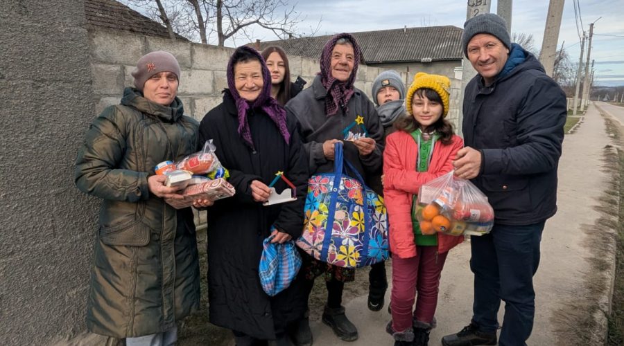 Victor, a volunteer, and two children posing with three beneficiaries.