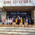 Children with their gifts in front of a school.