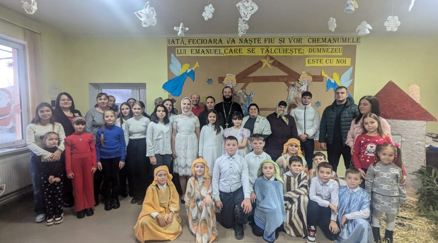 Children, parents, the priest, and AO Neemia staff posing for a picture.