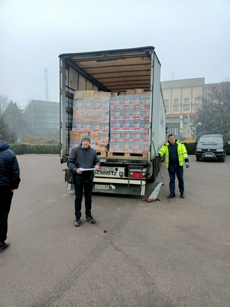 Victor posing in front of the semi-truck full of gifts.