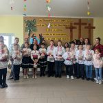 The children at the community center posing with their parents, Angela and Victor.