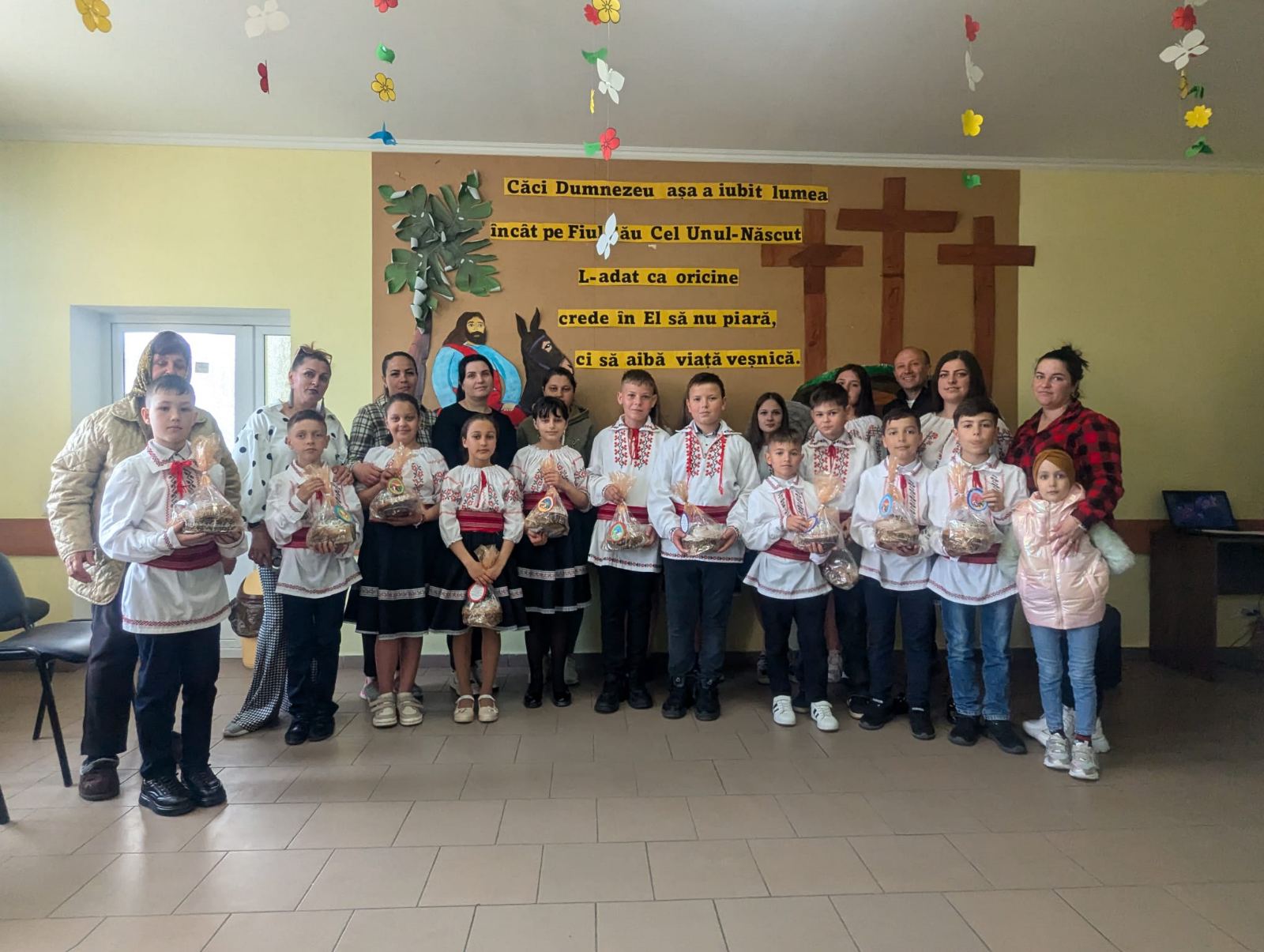 The children at the community center posing with their parents, Angela and Victor.