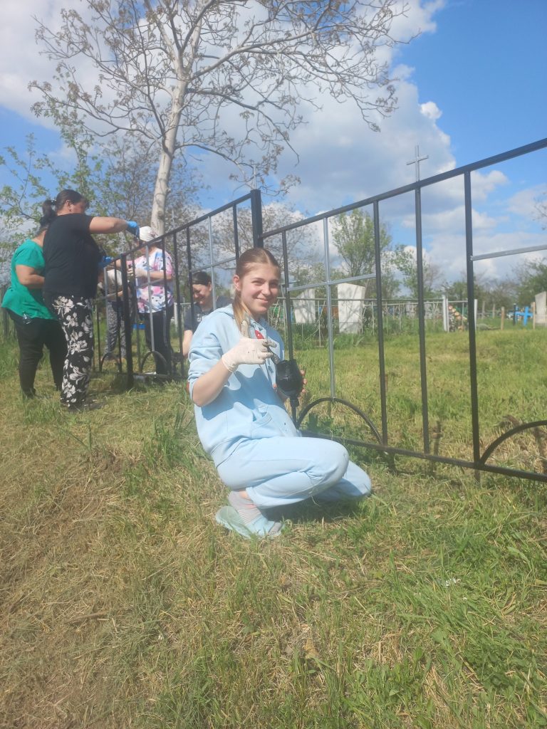 A youth volunteer from Neemia painting the fence