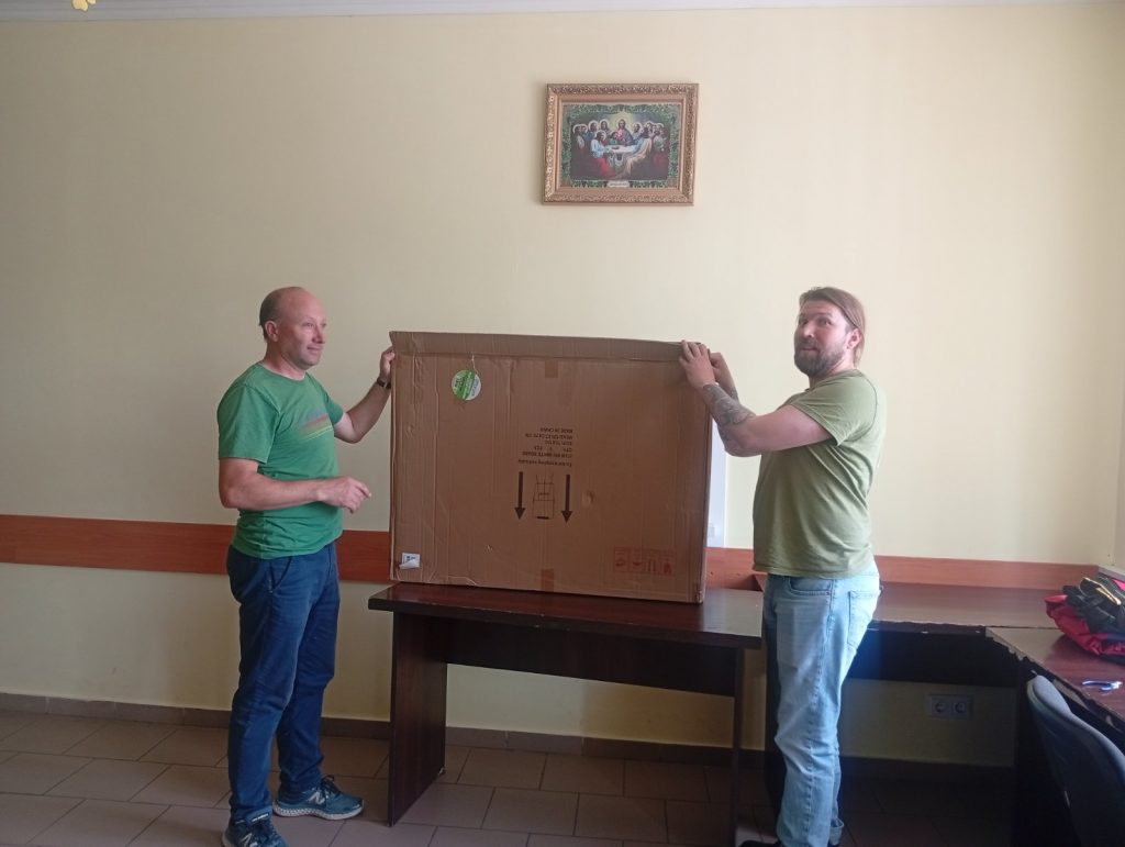 Victor and Adam holding up a box.