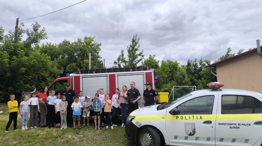 The children posing in front of the fire engine and the police car with the firemen and Mrs. Angela.