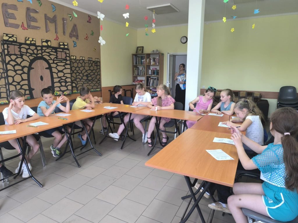 Many kids at the kids camp working on a handout.
