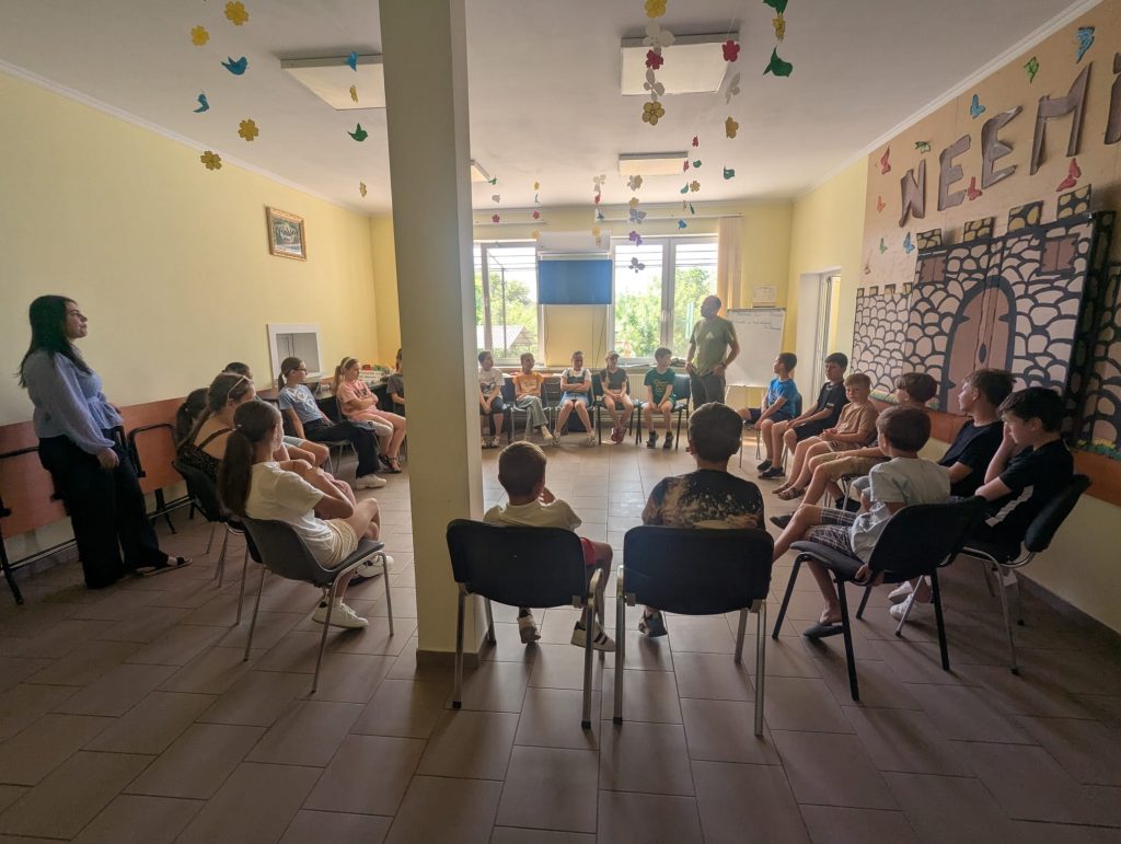 The children sitting in a circle while Mr. Victor tells bible stories.